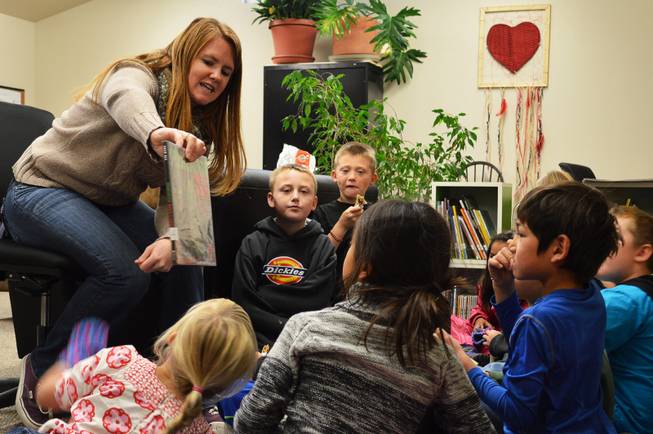 Michael-Ann Lazzarino shows children a book in the children's book nook in Virginia City in 2013. Lazzarino is the elementary programs director of Community Chest, a nonprofit group that opened the book nook last year in its community center. The Storey County Public Library closed in 2012.